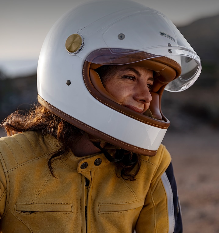 A close-up of a female motorcyclist wearing a helmet.
